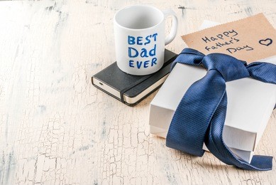 father's day gift concept, greeting card background, gift box, tie decoration, mug with inscription best dad ever, notebook, copy space