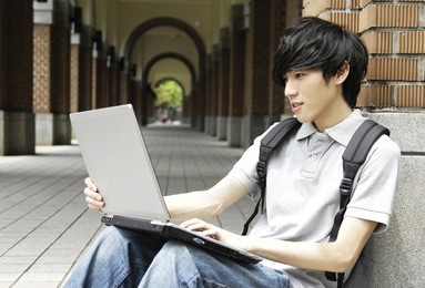  asian college student sitting student with laptop on campus