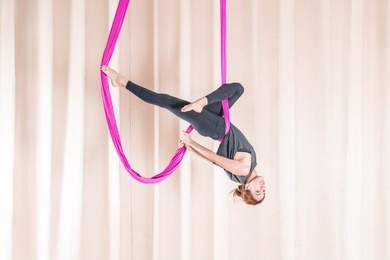 asian woman training in a fitness room with fly yoga elements