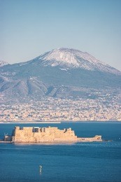 panoramic view of the famous gulf of naples, with castel dell'ovo (egg castle) and the vesuvius on background