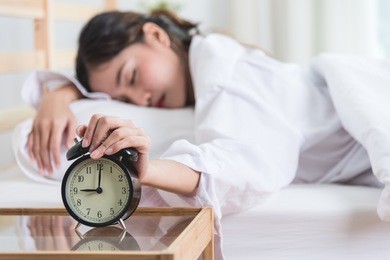 sleepy young woman with ringing alarm, wake up, not getting enough sleep
