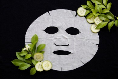 natural sheet mask health care for skin face from cucumber on background black