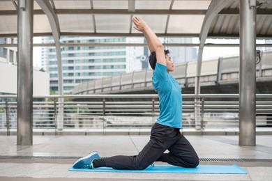 young man sitting exercise with pose yoga meditation on blue mat in city