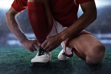 soccer player tying shoes