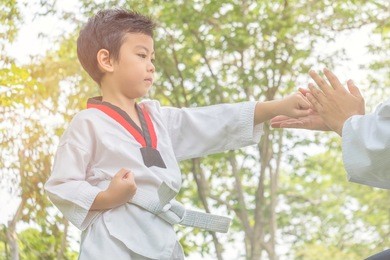 teacher teaching taekwondo kids,that is a korean martial art, characterized by its emphasis on head-height kicks, jumping and spinning kicks, and fast kicking techniques.