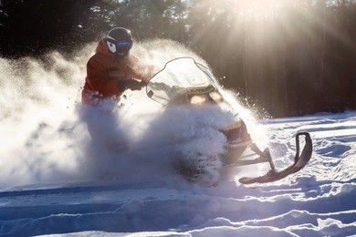 athlete on a snowmobile moving in the winter forest in the mountains of the southern urals.
