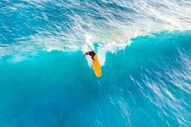 surfer ride on the waves in the ocean, top view