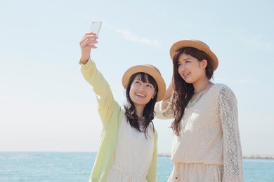 japanese girls to a commemorative photo at the seaside