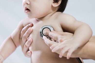 doctor examining asian baby girl and listen her heart beat with stethoscope in the hospital