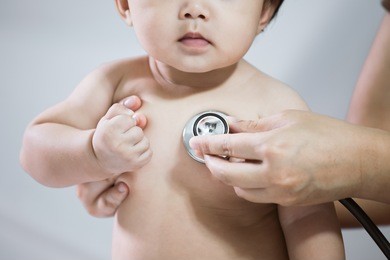doctor examining asian baby girl and listen her heart beat with stethoscope in the hospital