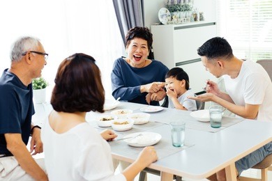 happy asian extended family having dinner at home full of laughter and happiness
