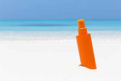 skin care on summer vacations. tube with sun screen spf protection lotion on tropical sea shore. copy space for your text