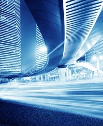 high-speed vehicles bright light trails on urban roads under the overpass at night