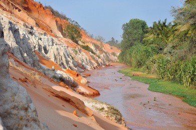 fairy stream (suoi tien), mui ne, vietnam. the small stream is the place where the desert meets the jungle. geological attraction with red and white sandstone