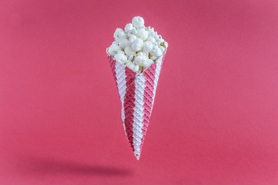 ice cream cone with popcorn isolated on red background minimal creative concept.