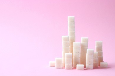 
a handful of sugar cubes on a pastel background. the sugar pyramid. minimalism, design, diabetes, sweets, calories. 
