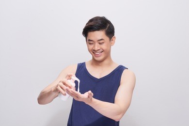 handsome man pouring washing foam on his hand.