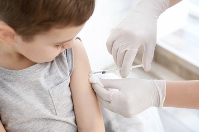 doctor vaccinating little boy in hospital