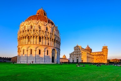 sunset view of baptistery of st. john (battistero di san giovanni), pisa cathedral (duomo di pisa) with the leaning tower (torre di pisa) on piazza dei miracoli in pisa, tuscany, italy