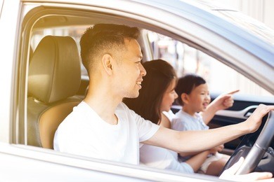 happy asian family is smiling and travelling on the road trip, going for a drive for vacation