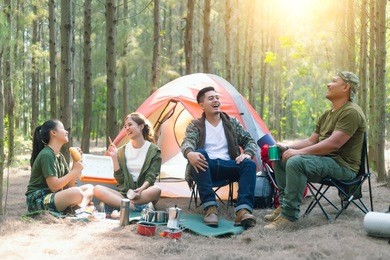 asian couple camping in their tent on the sunny day;vacation concept