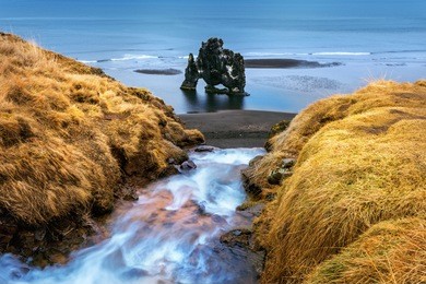 waterfall and hvitserkur is spectacular rock in the sea on the northern coast of iceland.