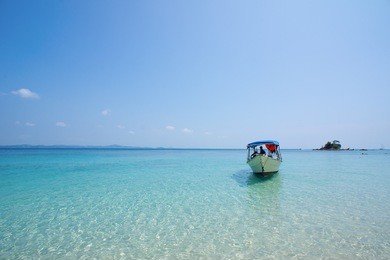 fishing boat floating on the sea water at kapas island tropical beach malaysia with blue sea and sky with copyspace