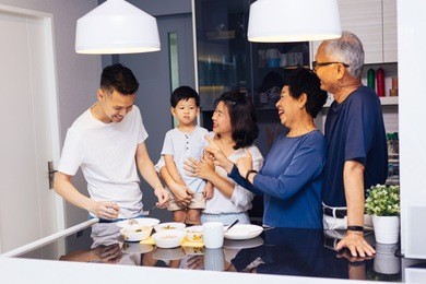 happy asian extended family preparing food at home full of laughter and happiness