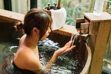 onsen series: asian woman relaxing in wooden bathtub