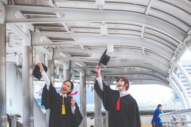 asia happy woman graduated are smiling and holding diploma and graduation caps with happiness.
