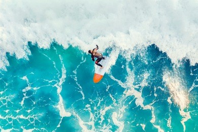 surfer at the top of the wave in the ocean, top view