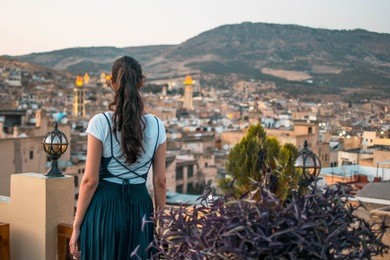 girl with dark long hair overlooking a medina in city fes, morocco