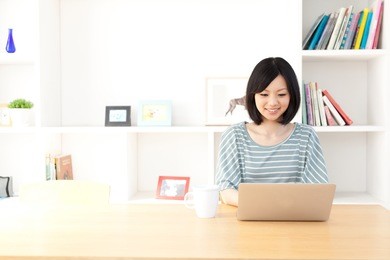a young asian woman using laptop in the dining room