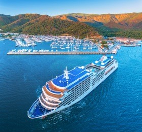 cruise ship at harbor. aerial view of beautiful large white ship at sunset. landscape with boats, mountains, sea, blue sky. top view of yacht. luxury cruise. floating liner in europe. travel. resort