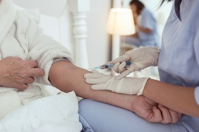 injection at home. close up of female hands making injunction while touching elder woman hand
