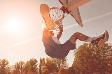 street basketball player performing power slum dunk