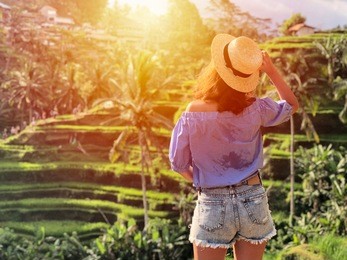 young woman looking at beautiful tegallalang rice terrace in bali, indonesia