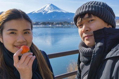 asian couple and valentines day travel concept.couple travelers man and woman travel the beautiful nature of mt. fuji in japan. travel and attractions concept.