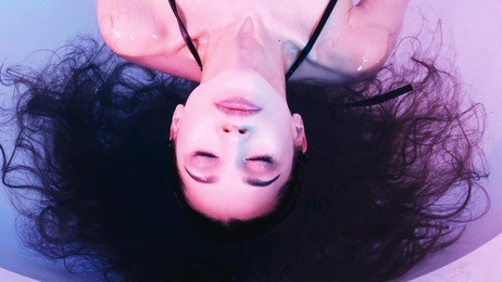 young woman floating in spa bath or swimming pool, she is very relaxed. welness concept.