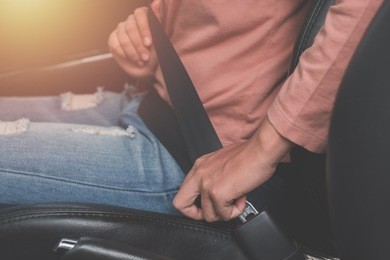 woman hands fastening seat belt in car.close up
