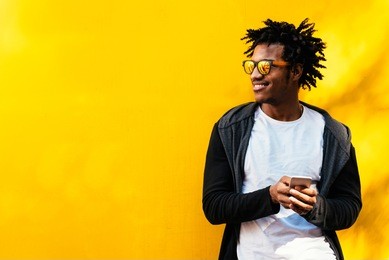 portrait of handsome afro man using his mobile in the street.