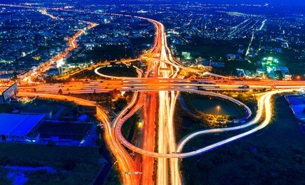 aerial view of cityscape and traffic on highway at night.