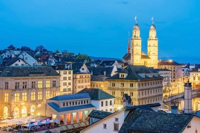 double towers of grossmunster church at dusk in zurich,  switzerland. view from lindenhof hill