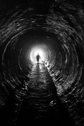 silhouette in a  communication tunnel. light at end of tunnel