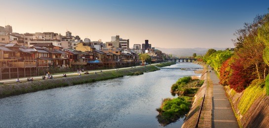 view to river kamo in evening light. people resting on the bank after working day near pontocho area