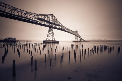 black and white photo of a bridge in the fog