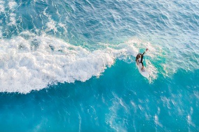 surfer at the top of the wave in the ocean, top view