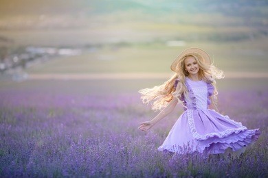 beautiful long-haired girl in a dress in a field of blooming lavender