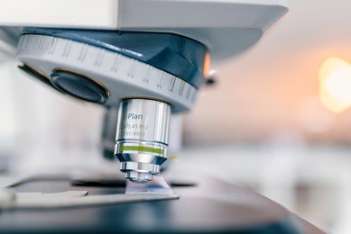 close-up shot of microscope with metal lens at laboratory. examining of test sample under the microscope in laboratory. medical equipment. microscope. background