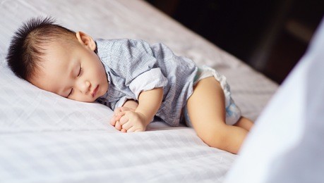 toddler kid sleeping peacefully on white bed 